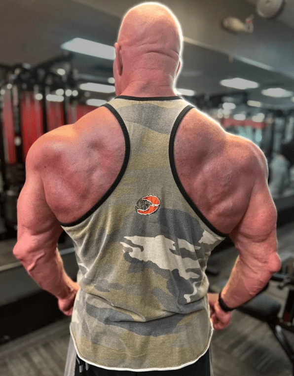 Bodybuilder in a gym facing away.