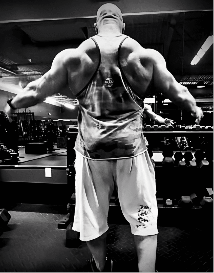 Bodybuilder posing in a gym mirror.
