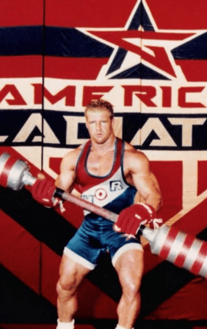 Athlete holding a large red and silver baton.