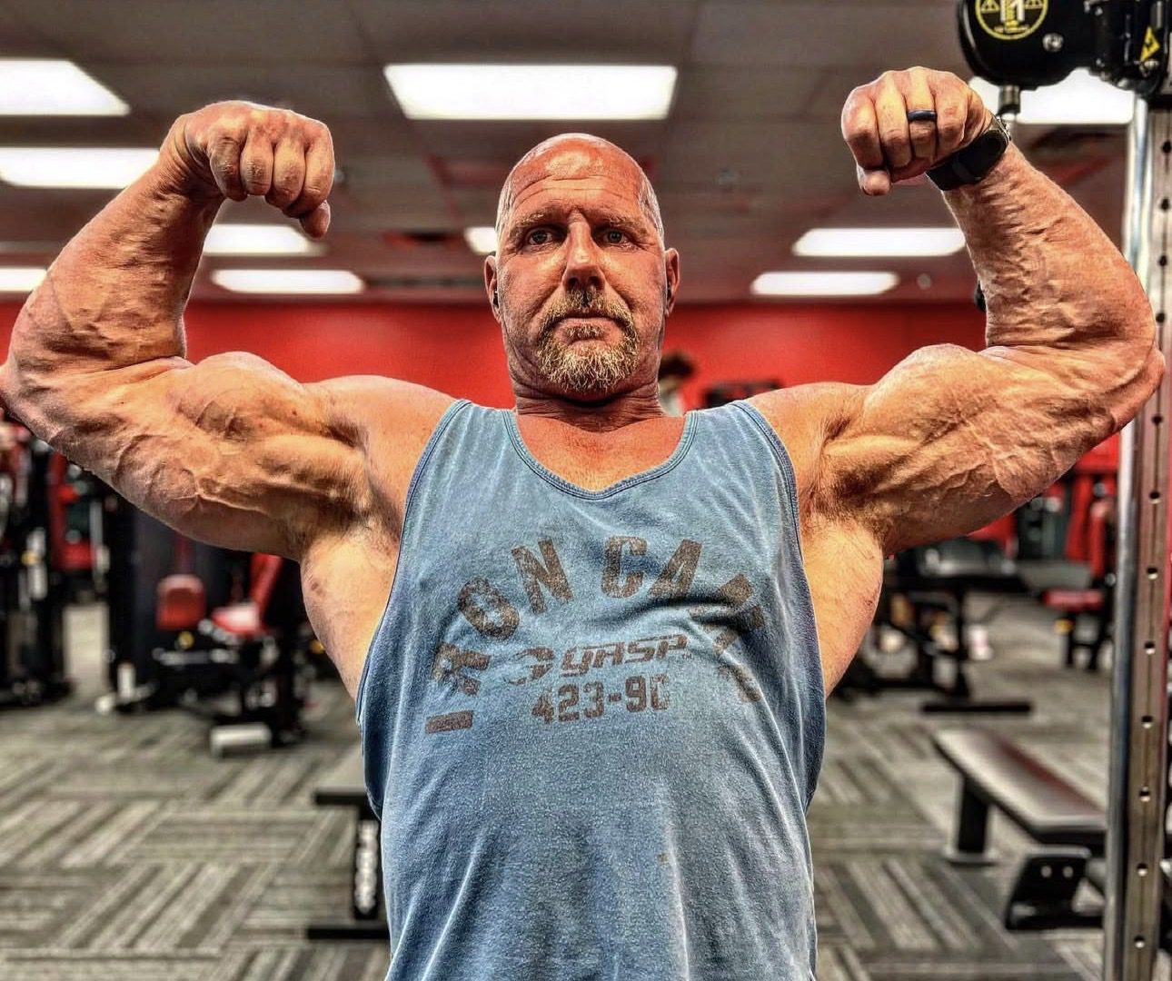 Muscular man flexing biceps in gym